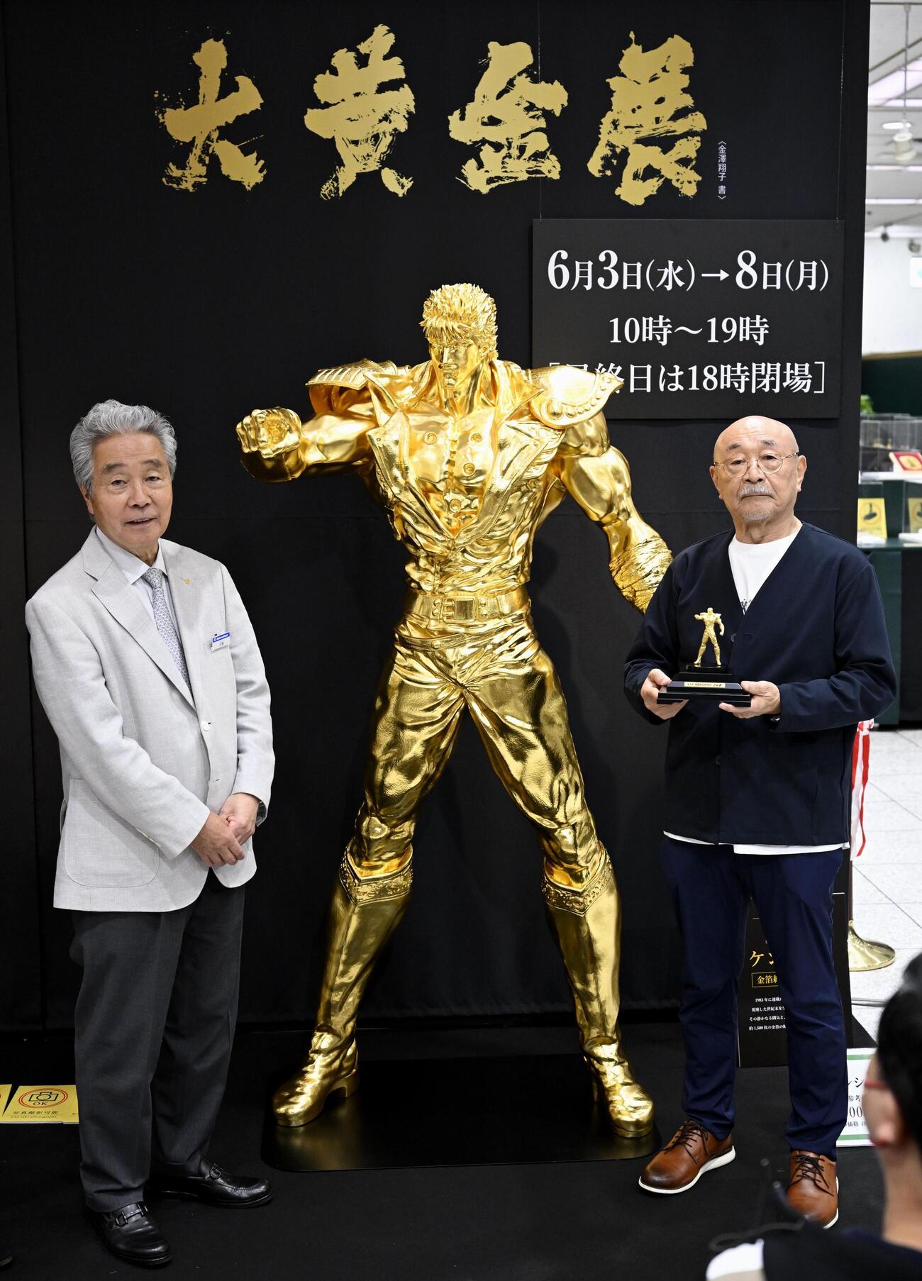 松坂屋名古屋店でお披露目された、漫画「北斗の拳」の主人公ケンシロウの黄金像。右は原作者の武論尊さん（共同）