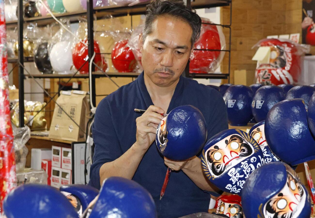 サッカーW杯北中米3カ国大会に合わせた必勝祈願だるまを作る「今井だるま店NAYA」の今井裕久代表（共同）