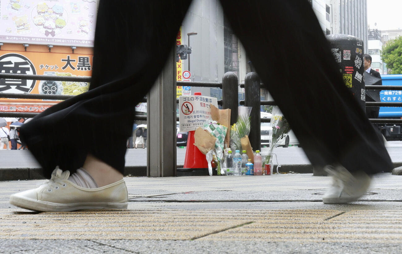 東京・秋葉原の無差別殺傷事件現場となった交差点に手向けられた花束＝8日午前（共同）