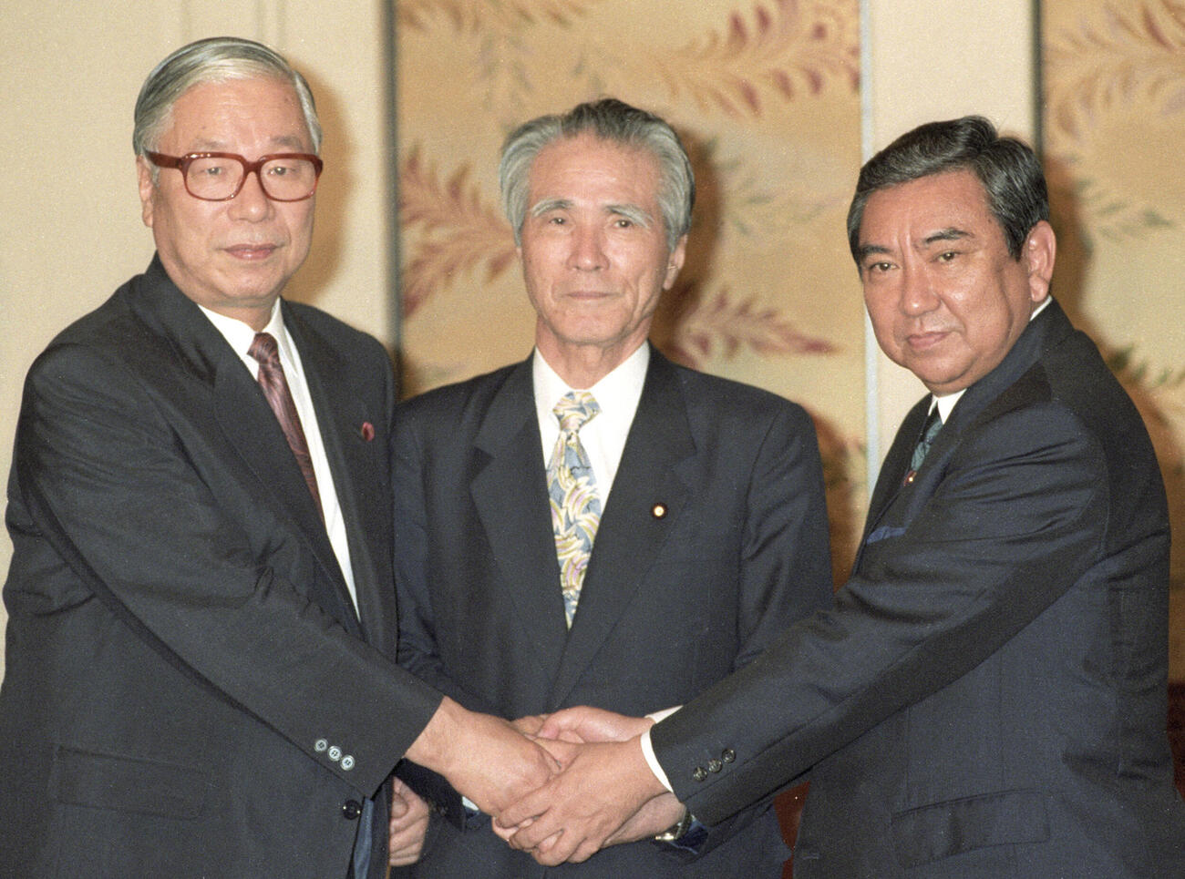 1994年6月、連立政権・組閣についての党首会談前に握手を交わす（左から）武村正義・新党さきがけ代表、社会党の村山富市新首相、河野洋平・自民党総裁＝国会