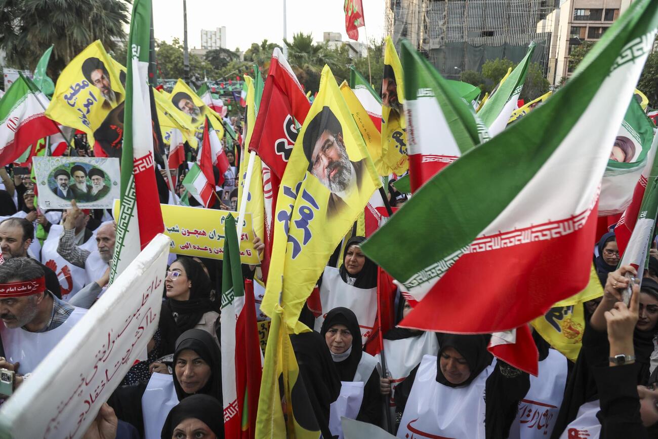 12日、イラン・テヘランで国旗などを手に広場に集まった人たち（ゲッティ＝共同）