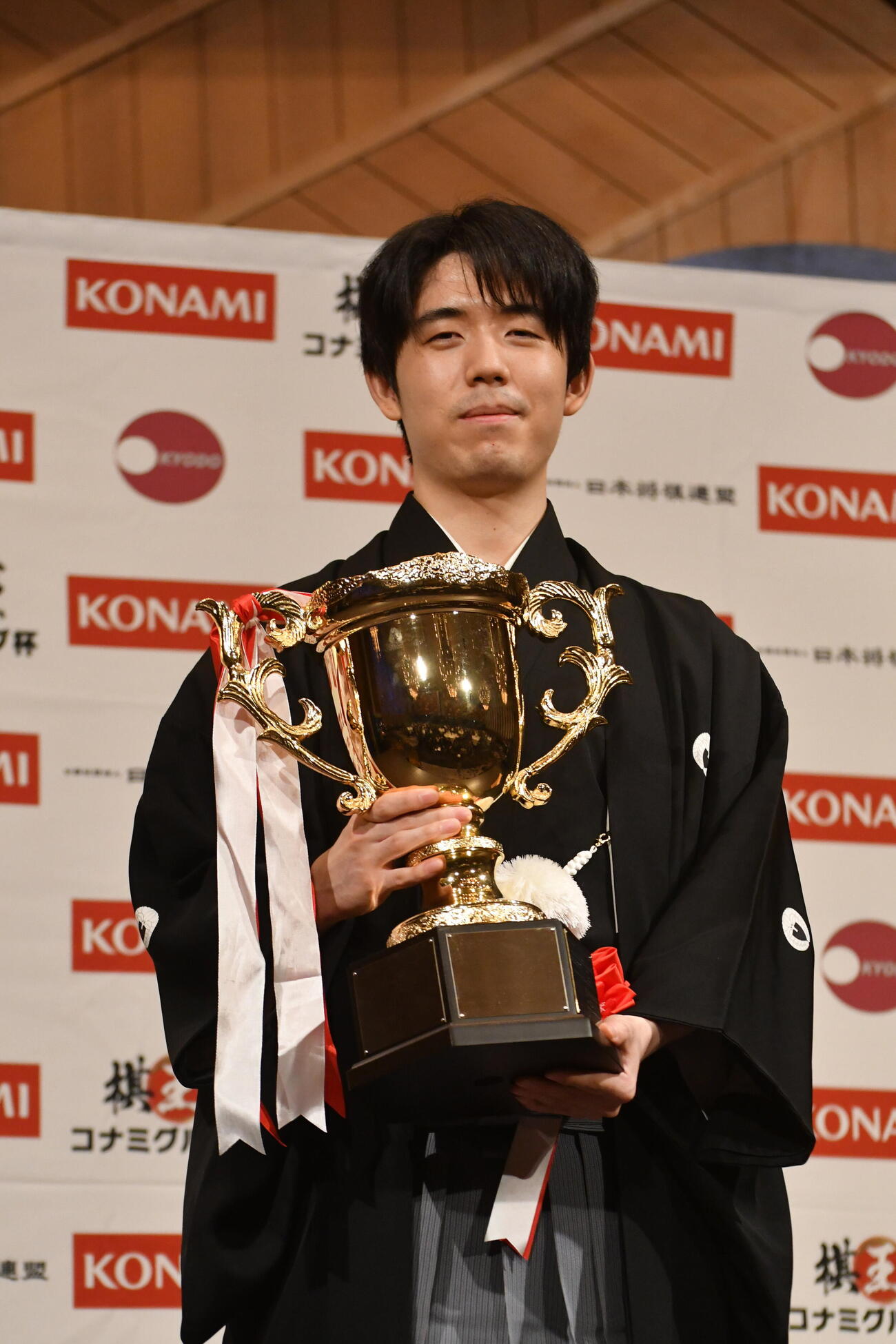 就位式で賞杯を手にする藤井聡太棋王