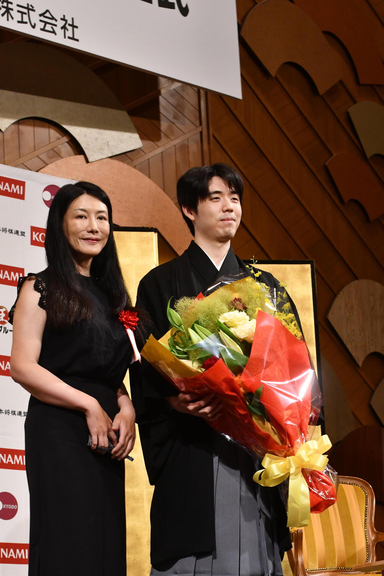 祝辞を述べた脳科学者の中野信子氏（左）から花束を贈呈された藤井聡太棋王
