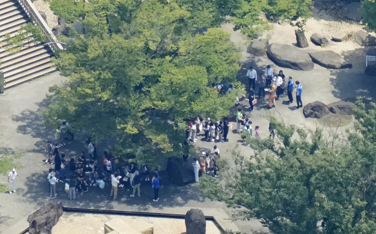 火災があった東京都北区立滝野川第三小付近の公園に避難した人たち＝19日午後0時8分（共同通信社ヘリから）(共同)