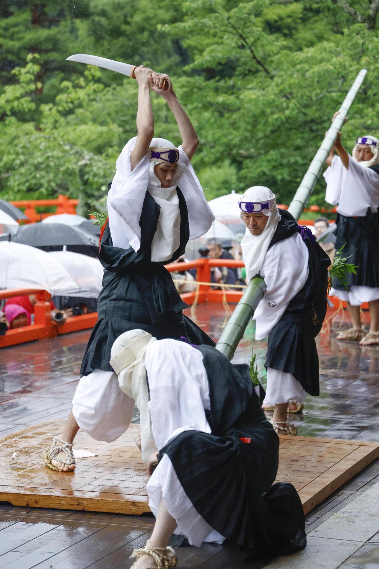 鞍馬寺の「竹伐り会式」で、大蛇に見立てた青竹をたたき切る僧兵姿の男性＝20日午後、京都市左京区(共同)