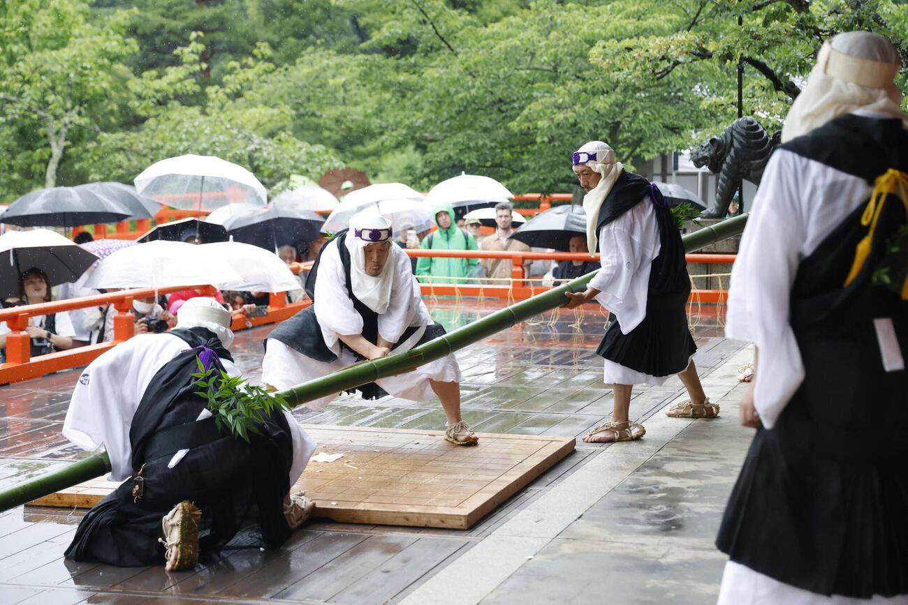 鞍馬寺の「竹伐り会式」で、大蛇に見立てた青竹をたたき切る僧兵姿の男性(共同)