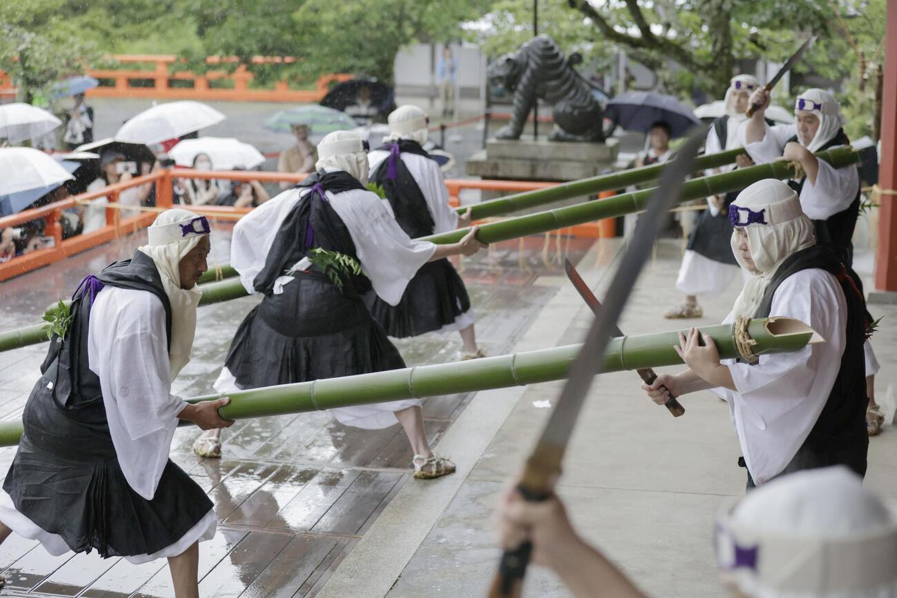 鞍馬寺の「竹伐り会式」で、大蛇に見立てた青竹をたたき切る僧兵姿の男性(共同)