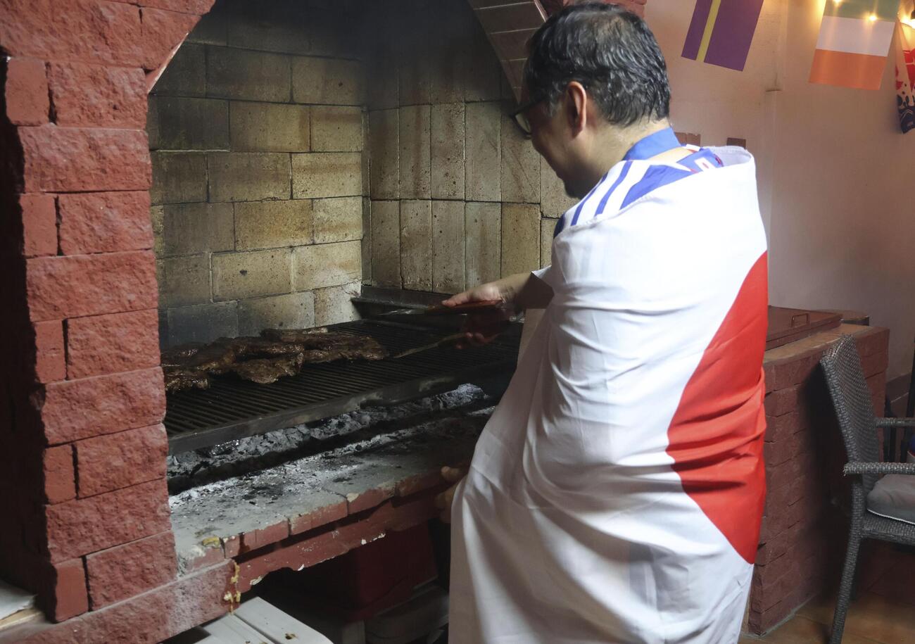 日の丸に身を包み牛肉を焼くダニエル・フルカワさん（共同）