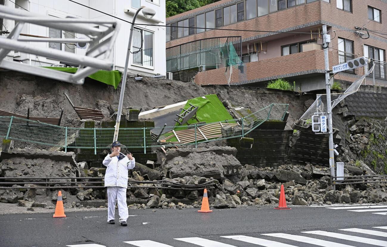 大雨の影響で崩れたのり面＝24日午後、鹿児島市（共同）