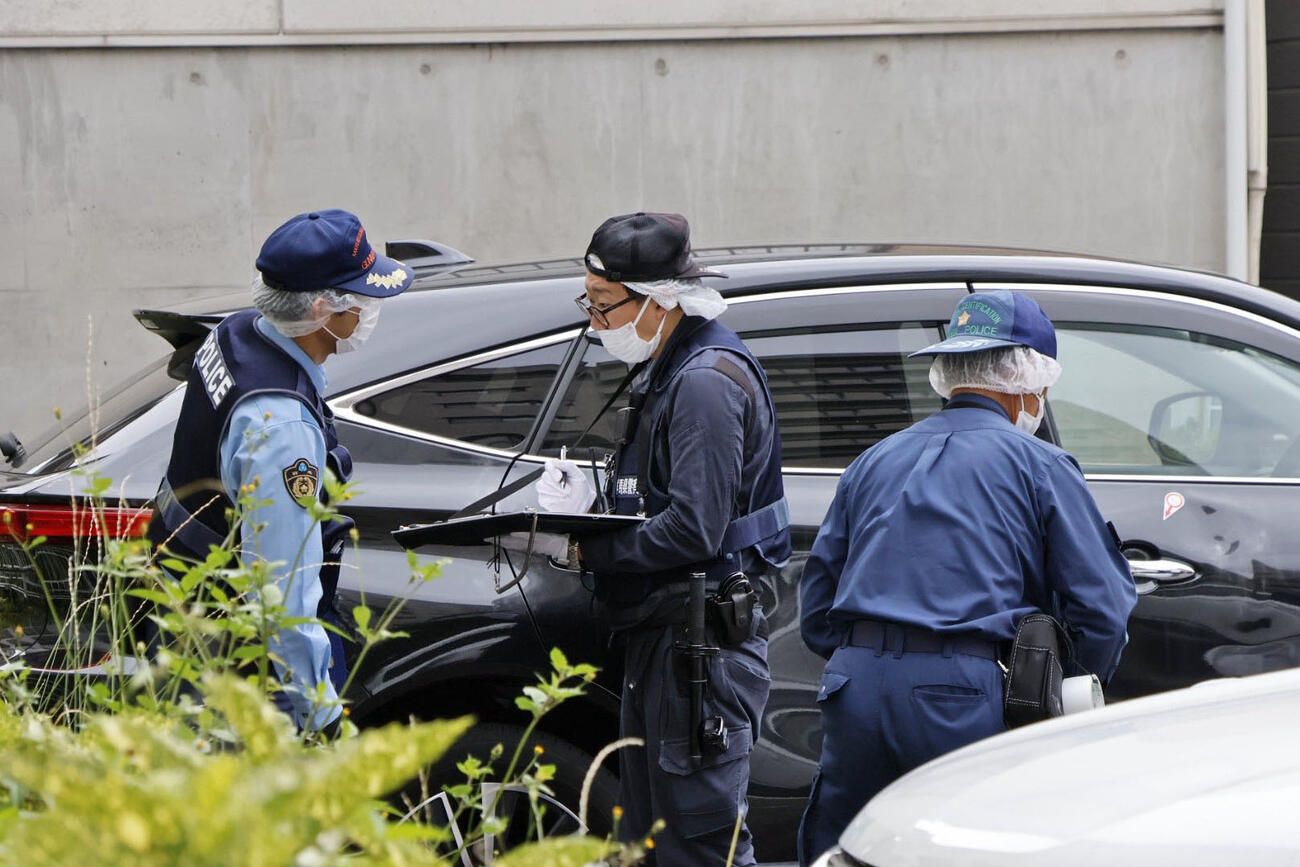 女性が見つかった駐車場を調べる群馬県警の捜査員ら＝24日午前7時9分、群馬県高崎市（共同）