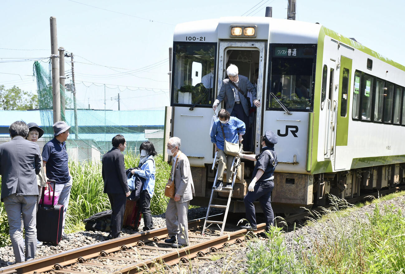 地震の影響で停車したJR大湊線の列車から降りる乗客たち（東奥日報社提供）