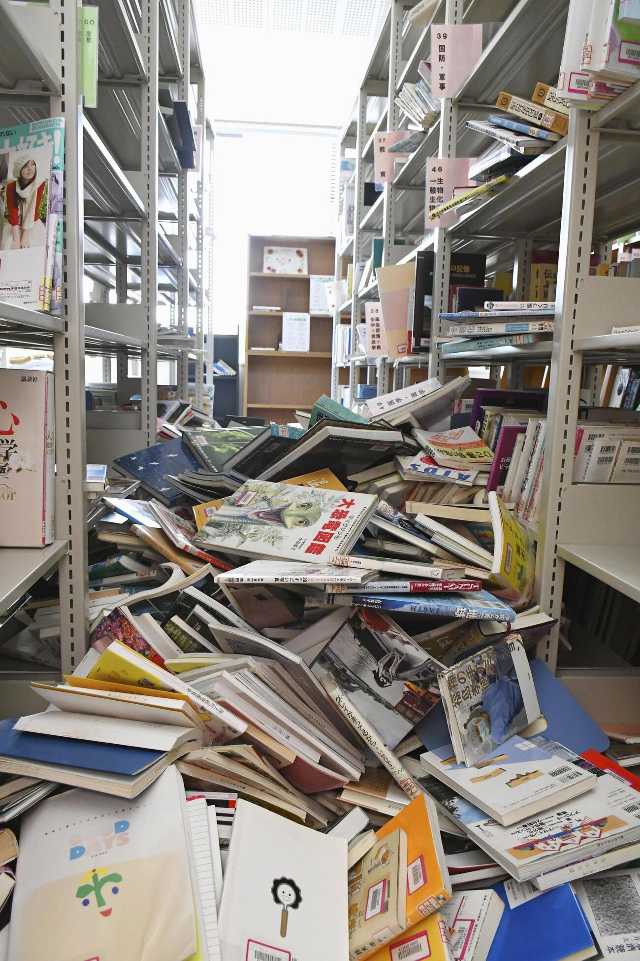 本棚の本が散乱した青森県階上町にある施設の図書室（東奥日報社提供）