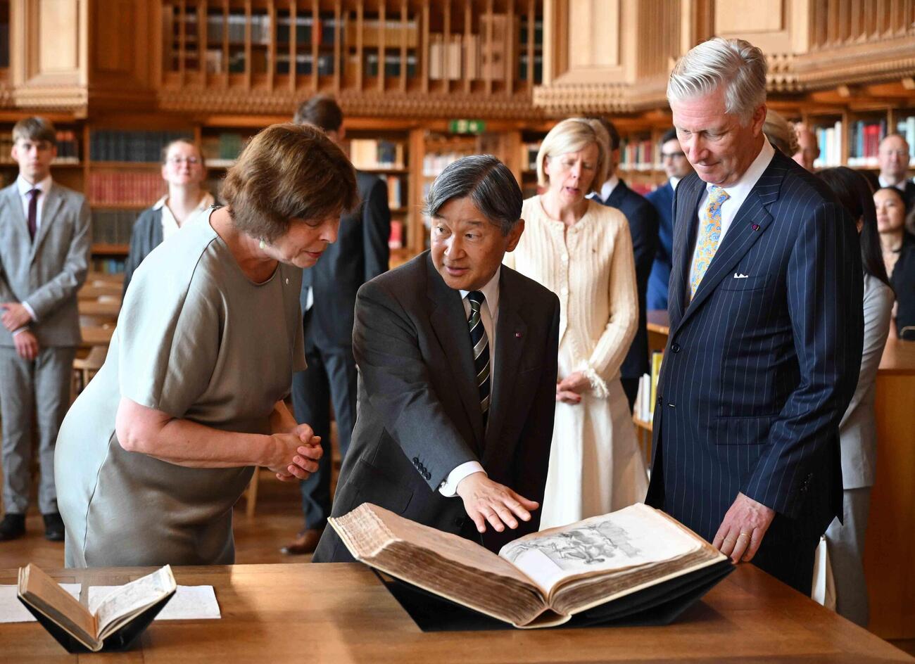 ルーベン大を訪問し、図書館で本を鑑賞される天皇陛下。右はベルギーのフィリップ国王（代表撮影・共同）