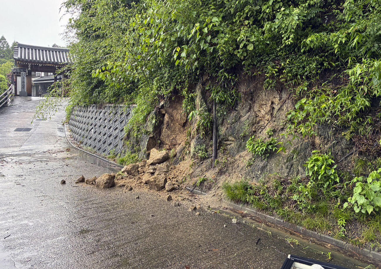 大雨の影響で崩れた斜面＝26日午前7時ごろ、京都府精華町、住民提供（共同）