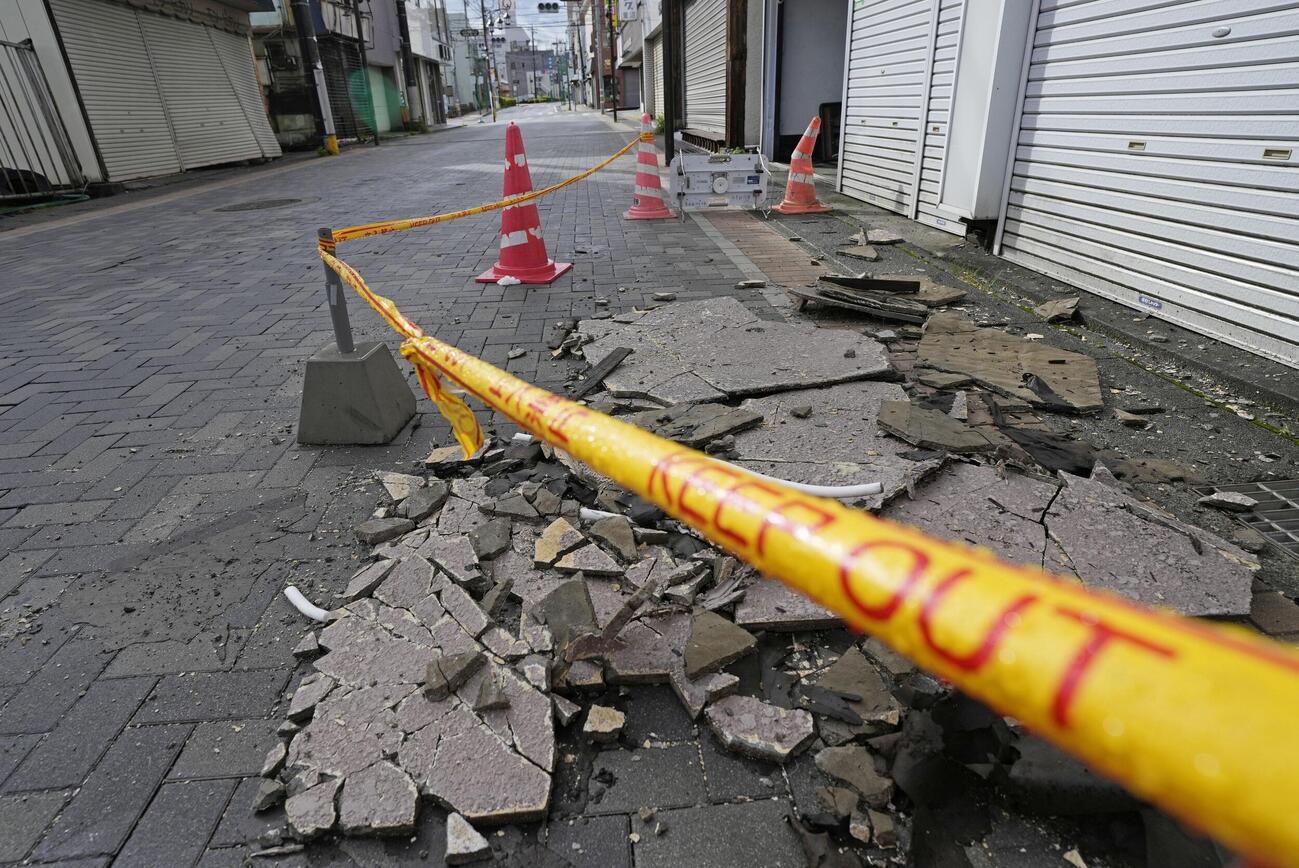 地震で崩れ、道路に散乱した建物の外壁＝27日午前7時17分、山梨県富士吉田市（共同）