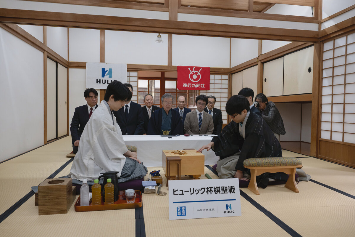 棋聖戦第3局に臨む藤井聡太棋聖（左）と駒を並べる服部慎一郎七段（右、日本将棋連盟提供）
