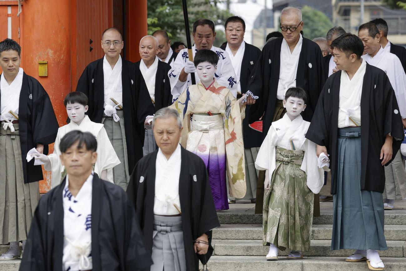 京都・祇園祭の無事を祈願する「お千度の儀」で、八坂神社を参拝する稚児の長谷航太郎さん（中央）ら（共同）