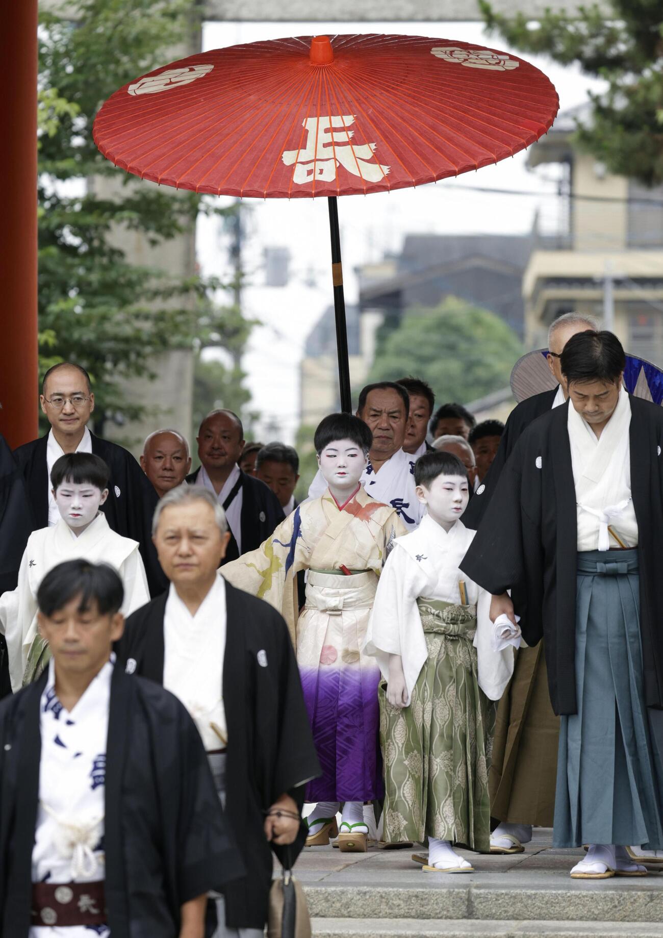 京都・祇園祭の無事を祈願する「お千度の儀」で、八坂神社を参拝する稚児の長谷航太郎さん（中央）ら（共同）
