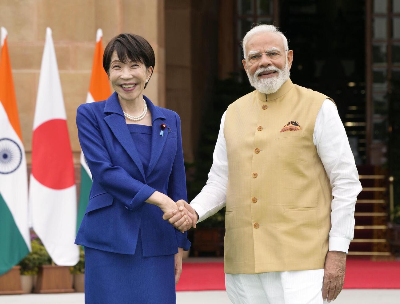 会談前に握手を交わす高市首相（左）とインドのモディ首相＝2日、ニューデリー（共同）