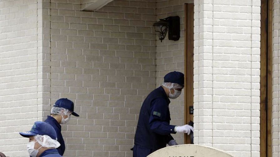 現場を調べるため、事件があった住宅に入る捜査員（共同）