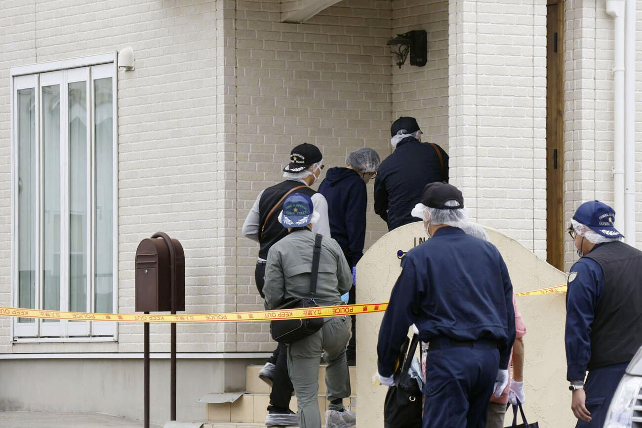 現場を調べるため、事件があった住宅に入る捜査員（共同）