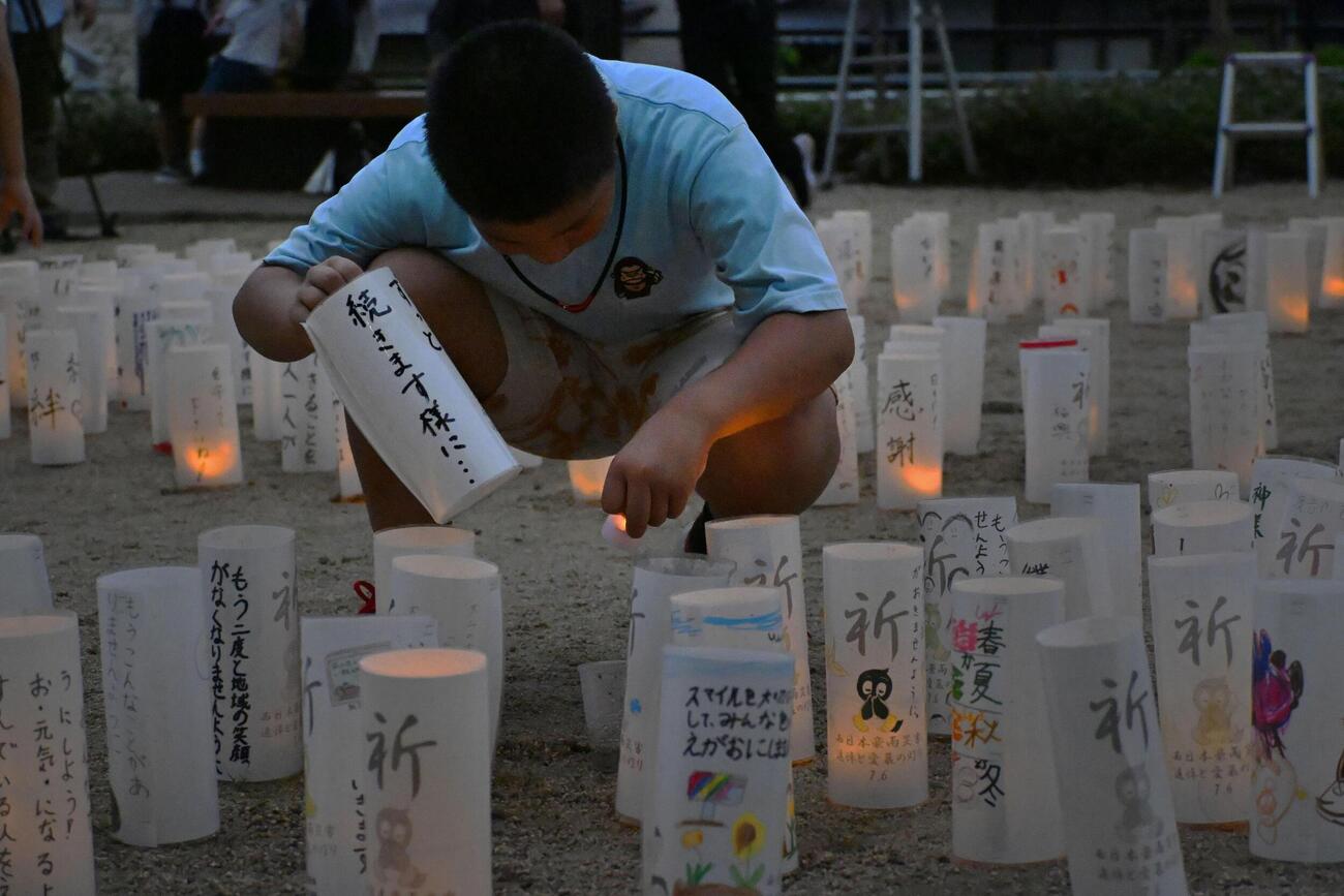 西日本豪雨から8年、広島県坂町小屋浦地区の公園で紙灯籠を準備する子ども（共同）