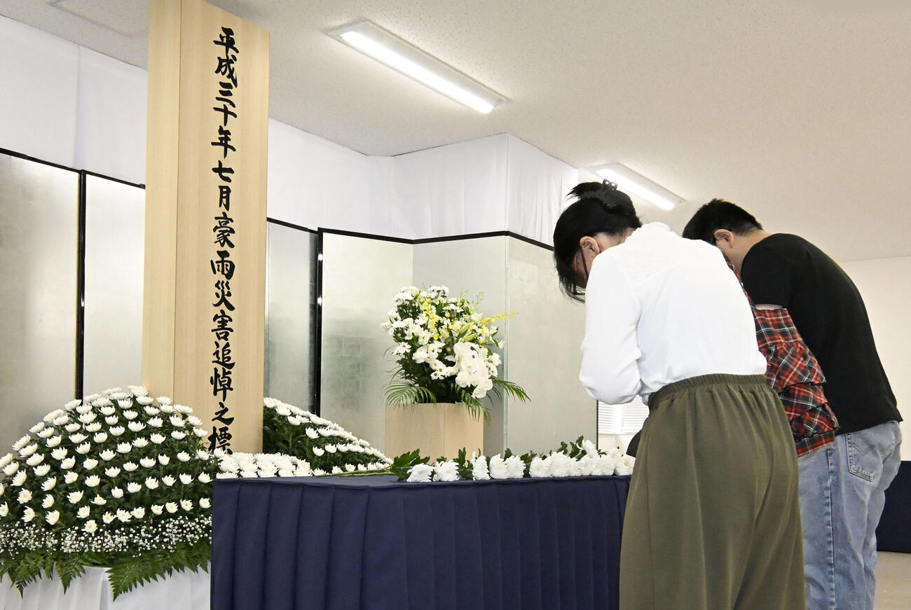 西日本豪雨から8年となり、岡山県倉敷市真備町地区で献花する人たち（共同）