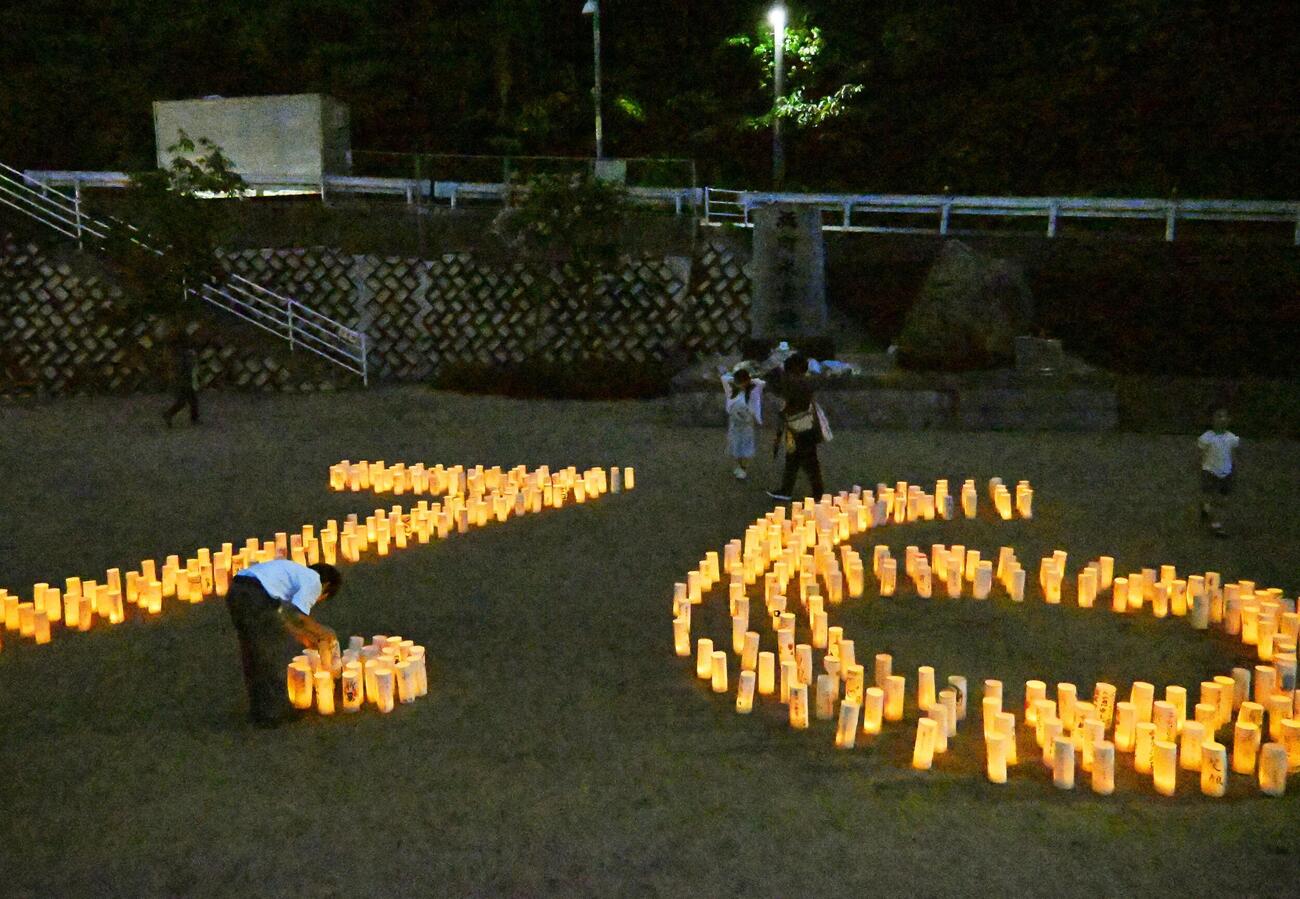 西日本豪雨から8年、広島県坂町小屋浦地区の公園で「7・6」の形に並べられた紙灯籠（共同）