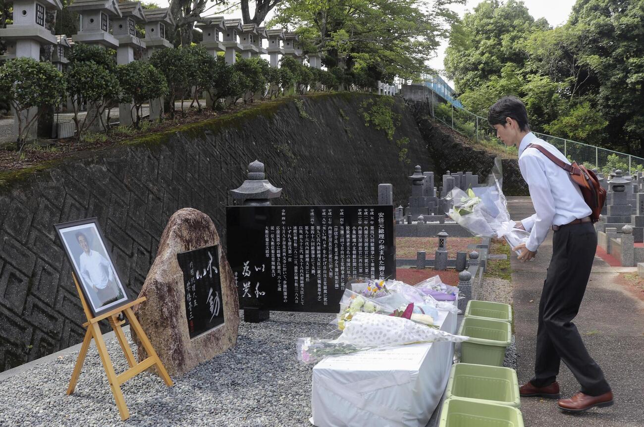 安倍元首相の慰霊碑に花を手向ける男性＝8日午前、奈良市（共同）