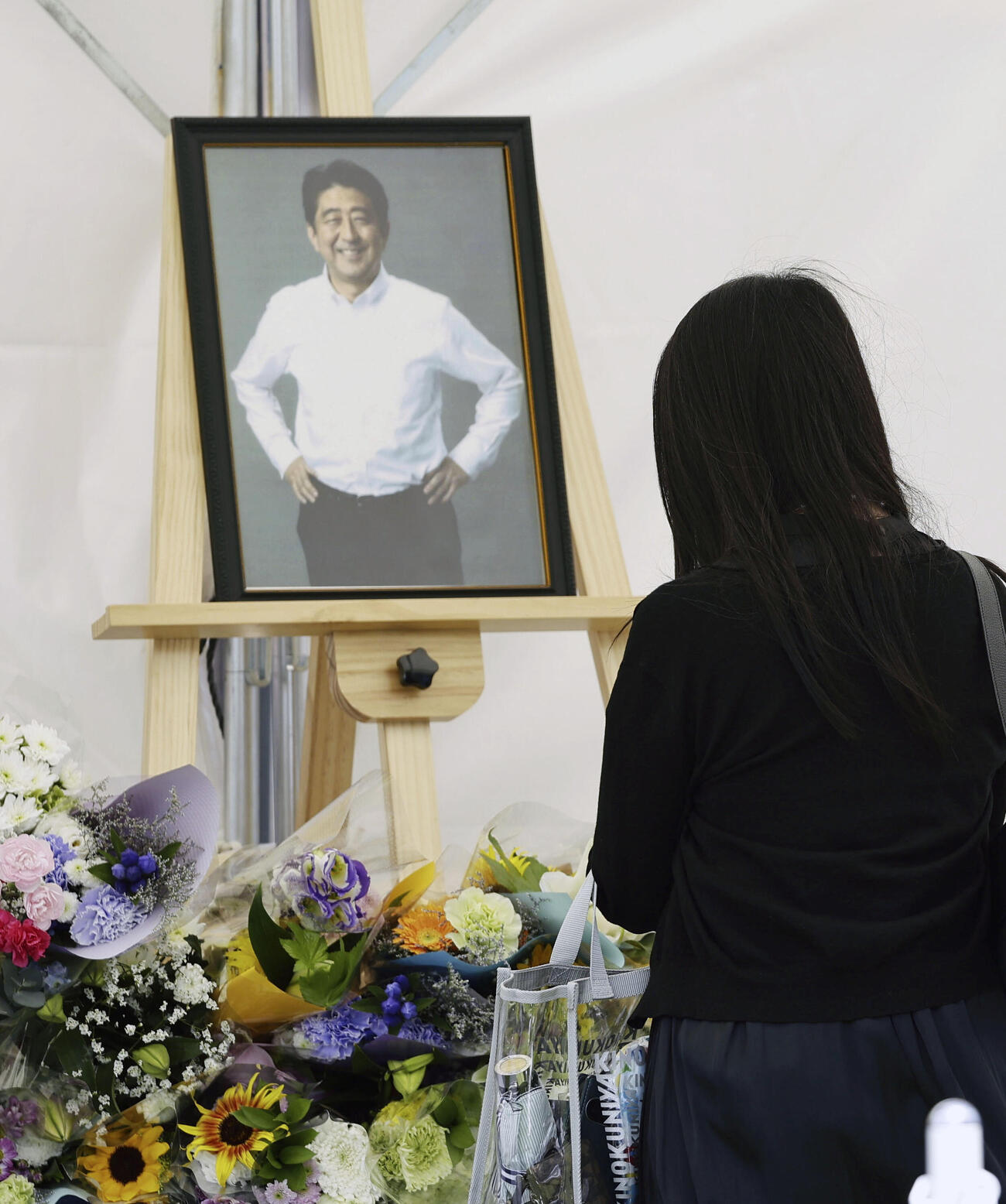 安倍元首相銃撃事件から4年、現場付近の献花台で手を合わせる人＝8日午前、奈良市（共同）