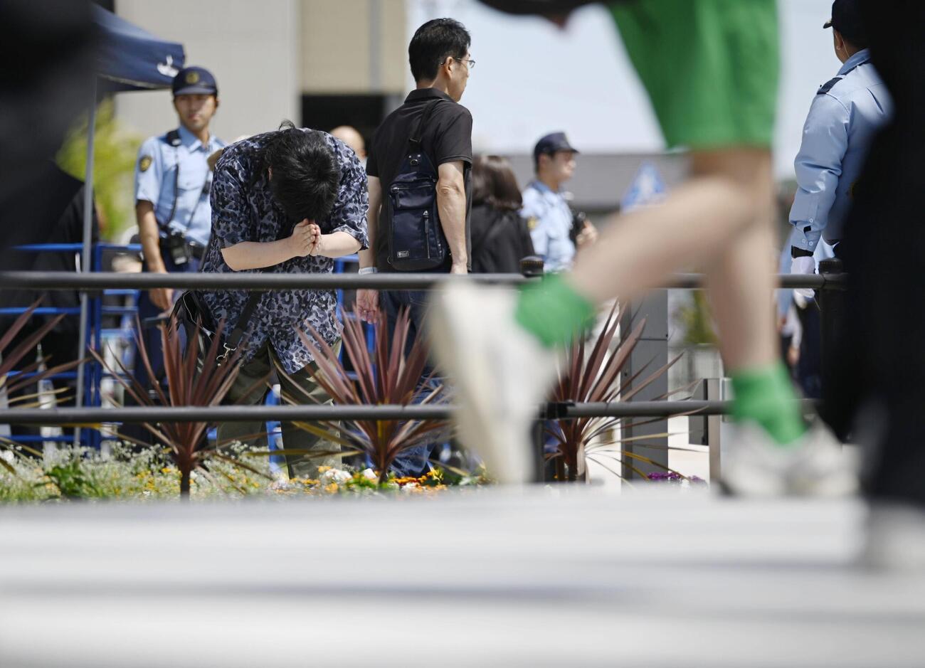 安倍元首相銃撃事件から4年、現場の交差点に向かい手を合わせる人＝8日午前、奈良市（共同）