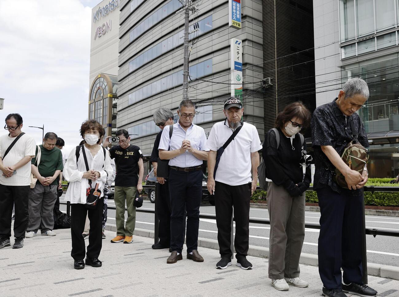 安倍元首相銃撃事件から4年、発生時刻に合わせて現場付近で黙とうする人たち＝8日午前、奈良市（共同）