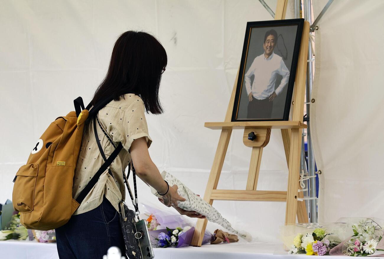 安倍元首相銃撃事件から4年、現場付近の献花台に花を手向ける人（共同）