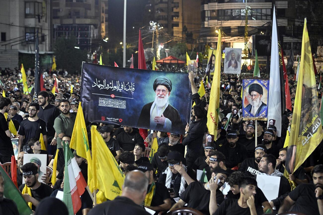 レバノン首都ベイルートで、イラン前最高指導者ハメネイ師を追悼する写真やイラン国旗を掲げる人々（共同）