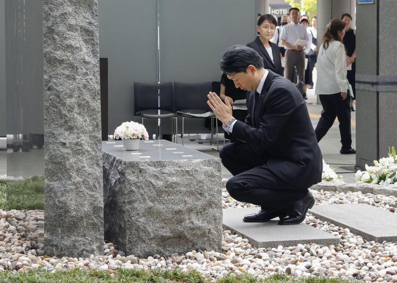 小学女児らが死亡した集団食中毒から30年となり、堺市役所前の追悼式典で献花し、祈りをささげる永藤英機市長＝12日午後(共同)