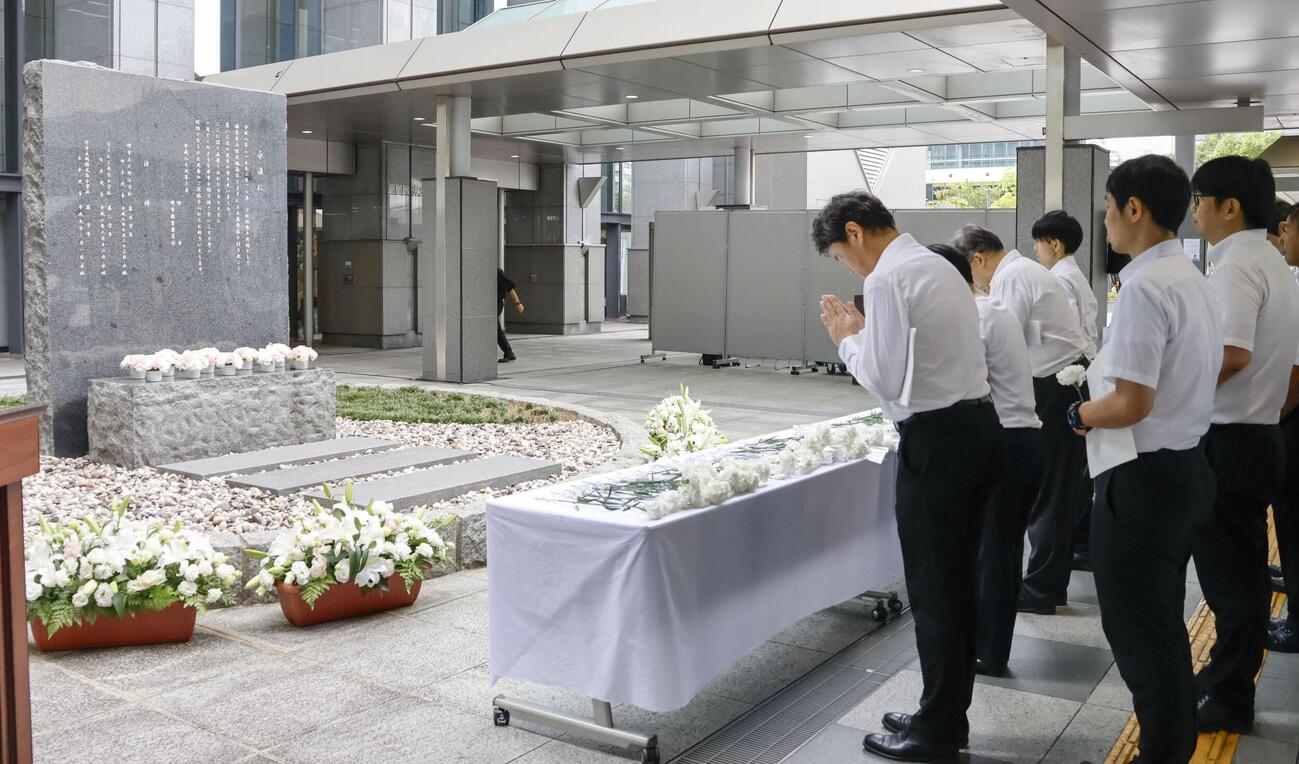 小学女児らが死亡した集団食中毒から30年となり、堺市役所前の追悼式典で献花し、祈りをささげる参列者＝12日午後(共同)