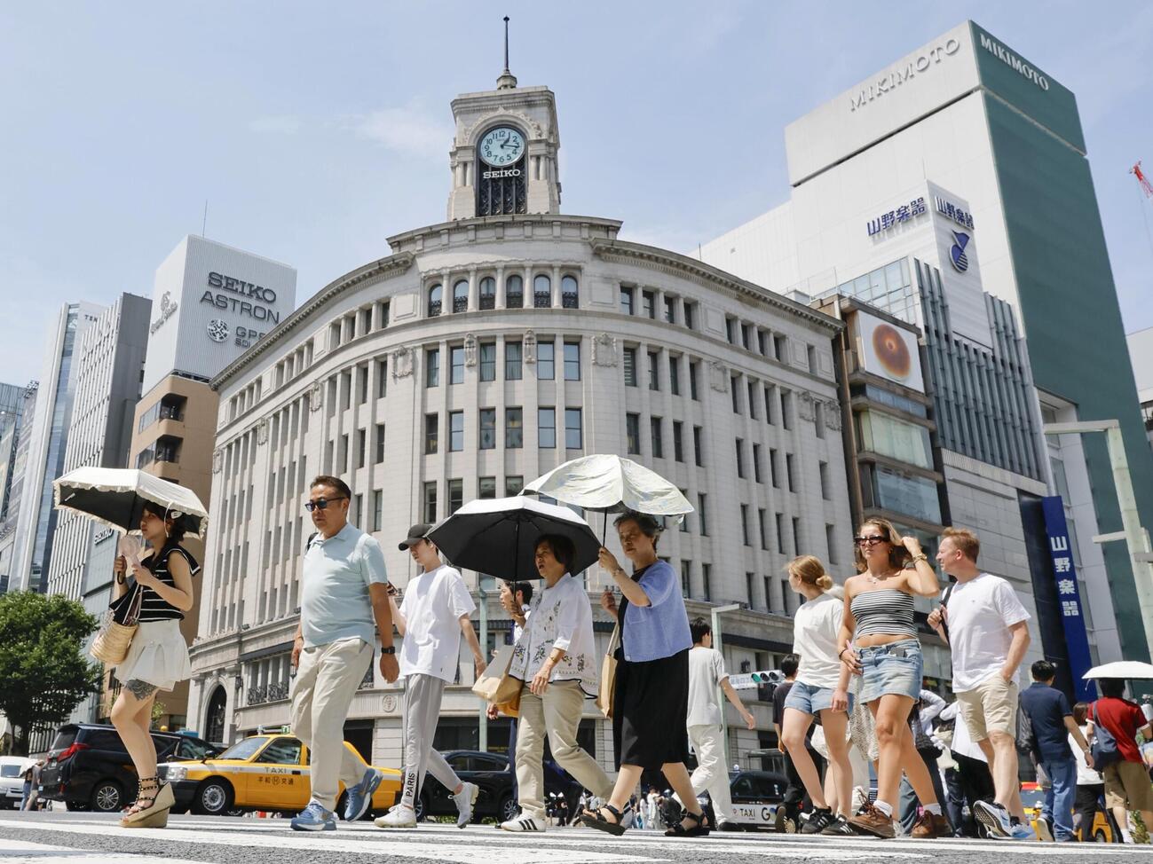 東京・銀座を日傘を差して歩く人たち（共同）