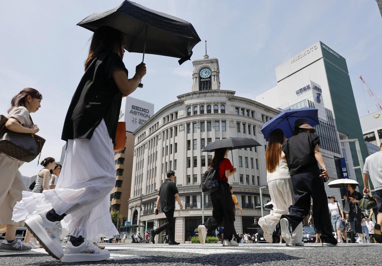 東京・銀座を日傘を差して歩く人たち（共同）