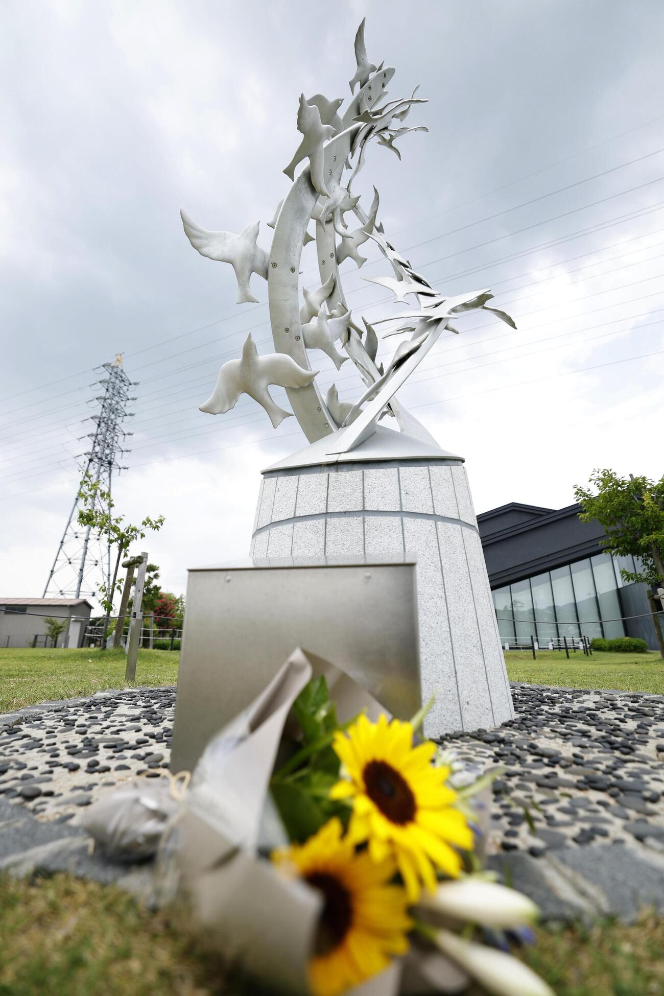 京都アニメーション放火事件から7年となり、花が供えられた「志を繋ぐ碑」＝18日午後、京都府宇治市（共同）