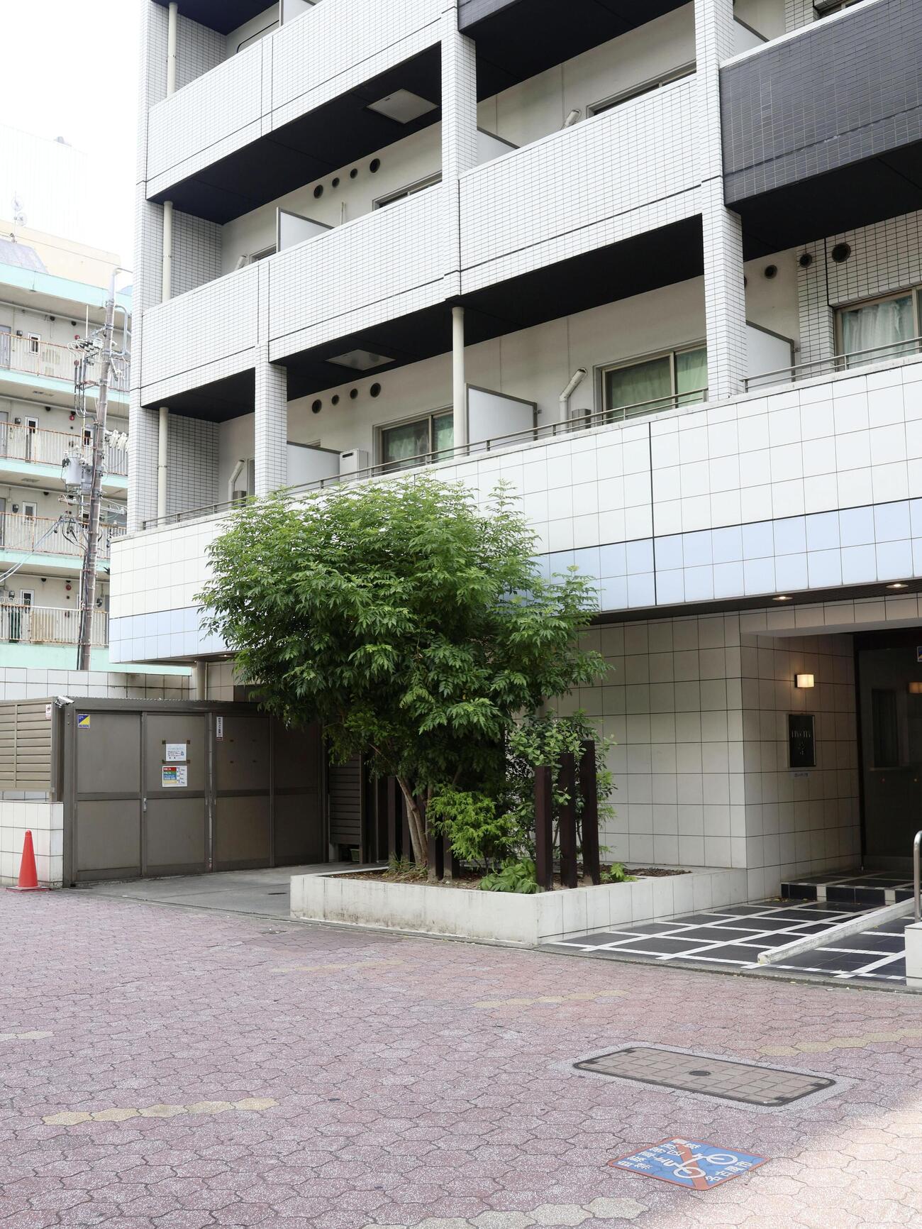 男性が転落し、ぶつかった歩行者の女性が死亡したマンション前の歩道＝19日午後、名古屋市中区(共同)