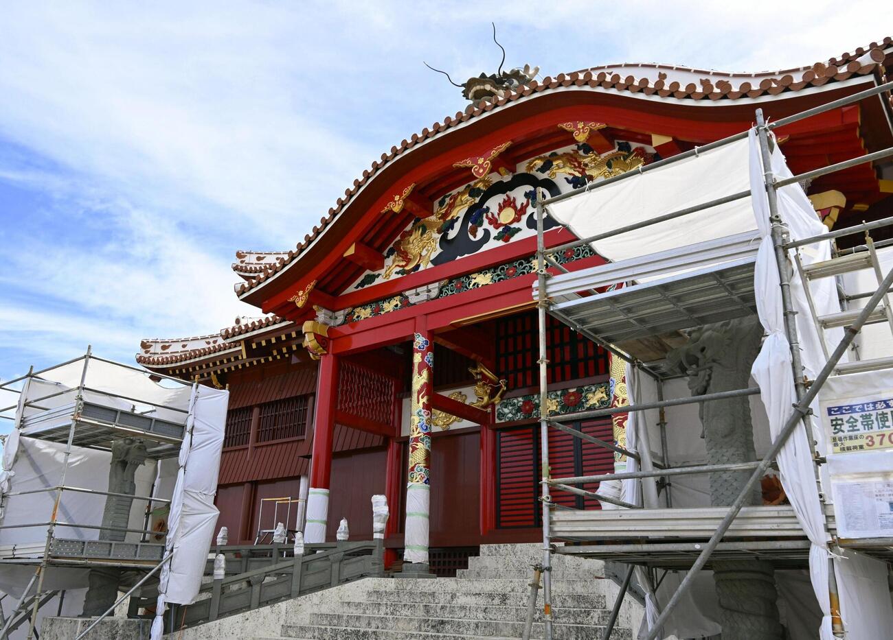 再建中の首里城で正殿前の左右に向かい合うよう配置された「大龍柱」。仕上げの彫刻が始まった＝24日午前、那覇市（共同）