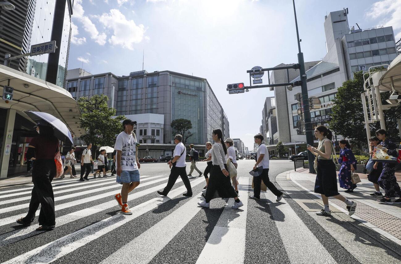 厳しい暑さの中、京都市内を歩く人たち＝23日午後