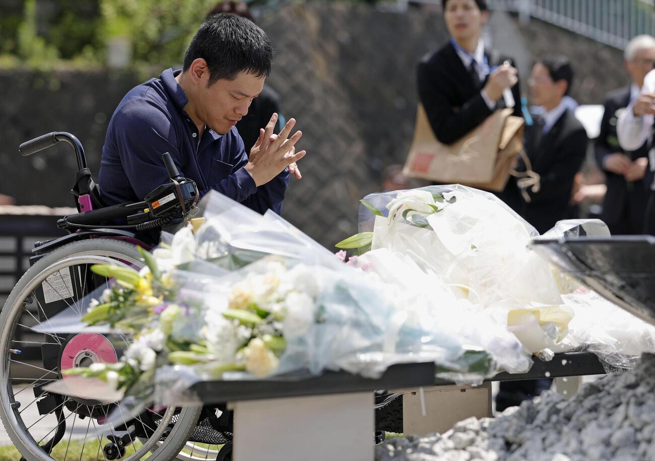 津久井やまゆり園の「鎮魂のモニュメント」に献花し、手を合わせる男性（共同）