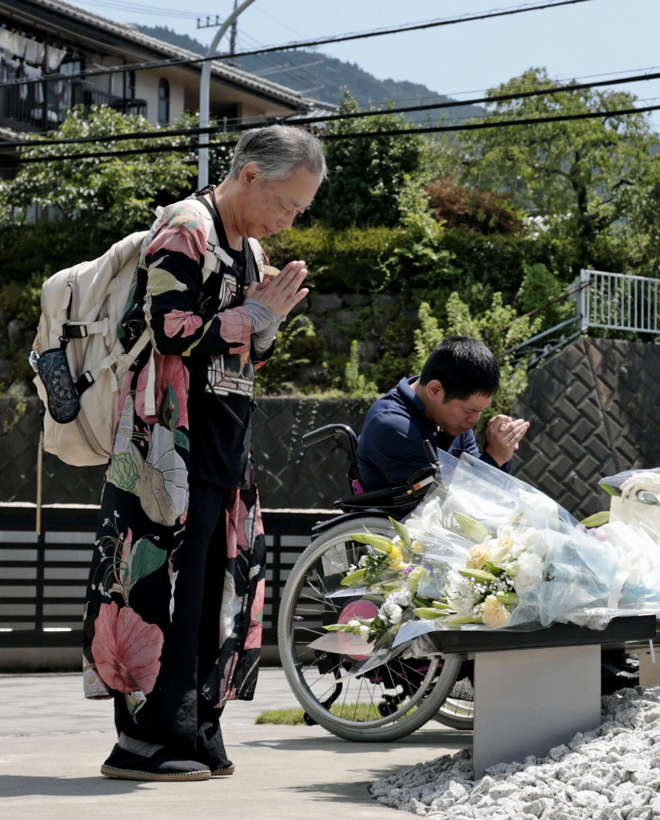 津久井やまゆり園の「鎮魂のモニュメント」に献花し、手を合わせる人たち（共同）