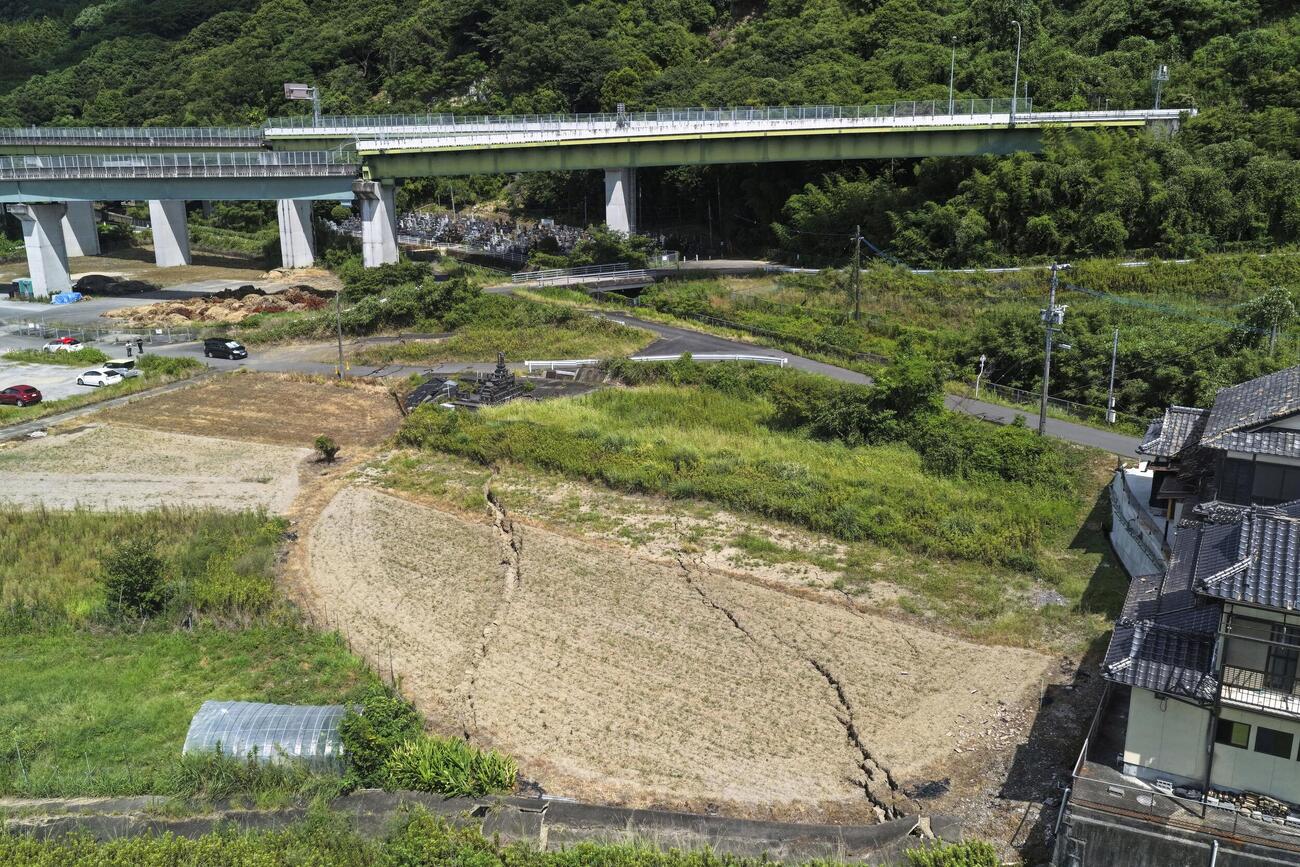 地震の影響で橋梁（きょうりょう）や道路が損傷した南九州自動車道の八代ジャンクション付近の地割れ＝29日午後2時20分、熊本県八代市（ドローンから）（共同）