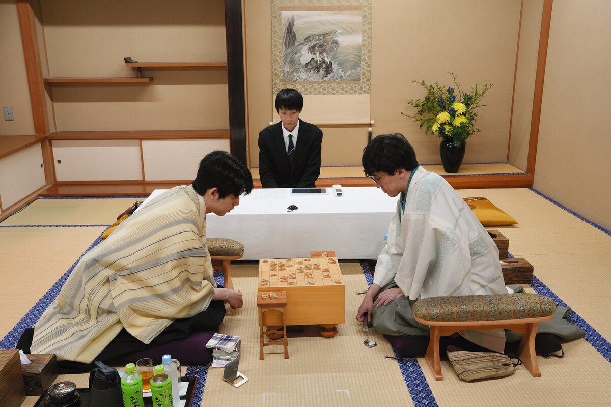 2日目の再開直後から盤上に集中する藤井聡太王位（左）と伊藤匠2冠（右、日本将棋連盟提供）