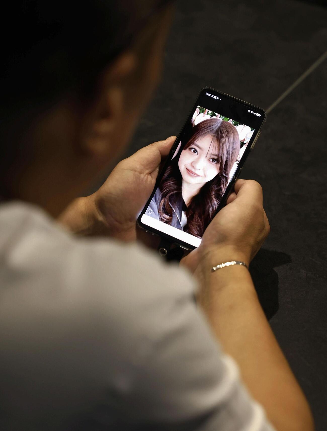 「イオンモール熊本」の爆発で亡くなった大竹玖瑠美さんの写真を見つめる親族の男性＝2日午前、熊本市（共同）