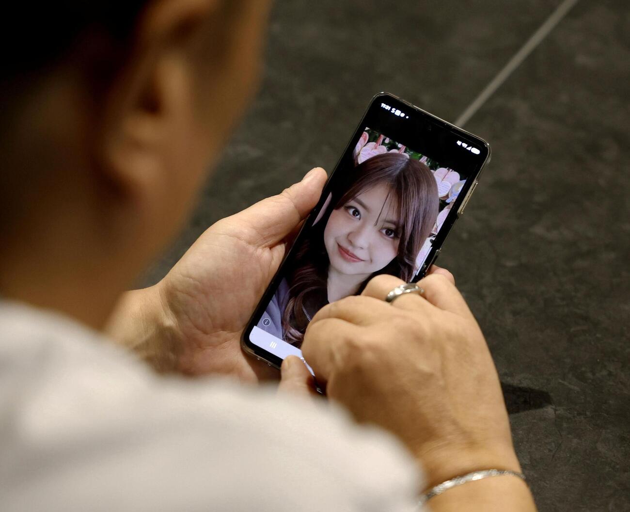 「イオンモール熊本」の爆発で亡くなった大竹玖瑠美さんの写真を見つめる親族の男性（共同）