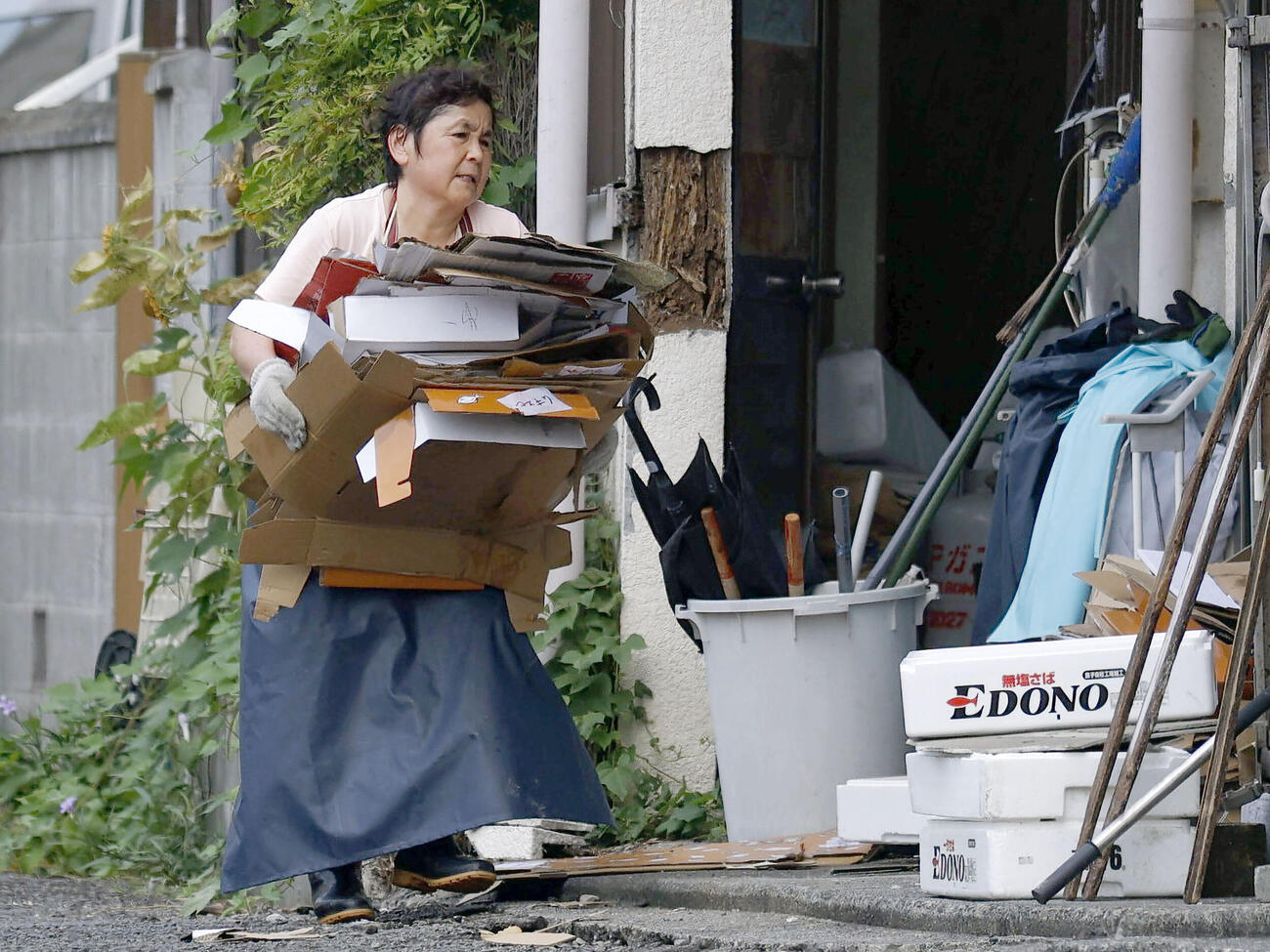 被災した鮮魚店で復旧作業に追われる女性（共同）