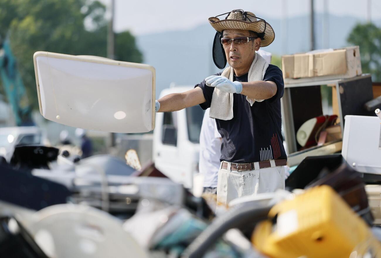 仮置き場に持ち込んだ災害ごみを荷台から降ろす男性（共同）